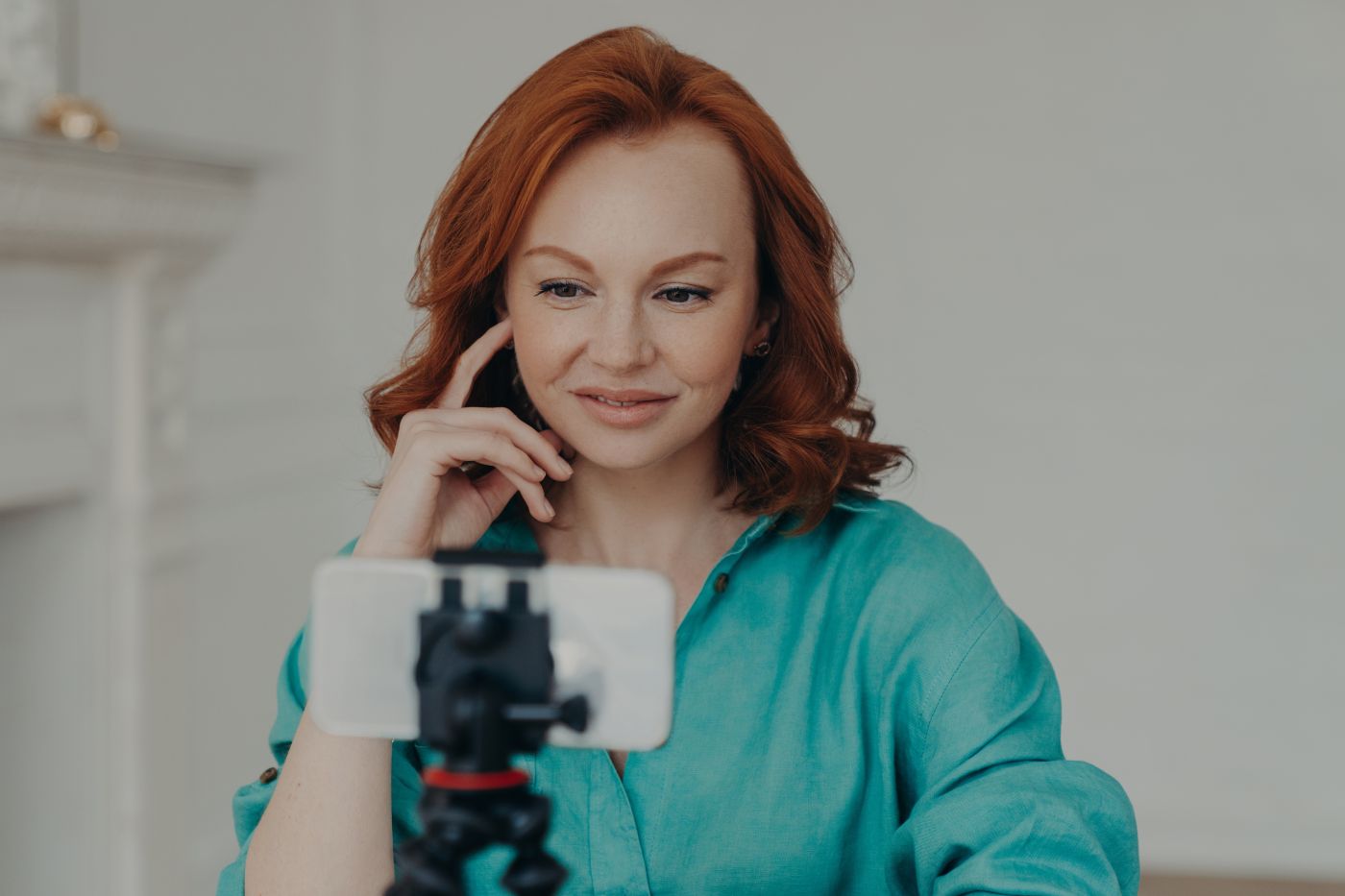 Photo Of Positive Redhead Woman Blogger Influencer Shoots Video For Personal Blog, Uses Modern Mobile Phone On Tripod, Does Online Chat, Shoots Blog At Home, Uses High Speed Internet Connection - Auster Inteligência Contábil