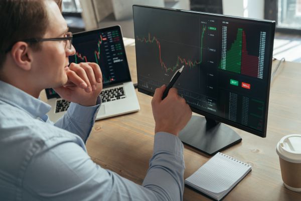 Concentrated Man Trader Pointing Pen At Pc Monitor With Diagram Of Stock Crypto Currency Market - Auster Inteligência Contábil