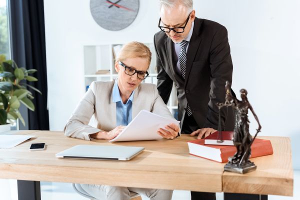 Serious Mature Lawyers With Paperwork In Modern Office - Auster Inteligência Contábil