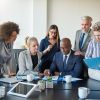 Diverse Group Of Colleagues Discussing Paperwork Together In An Office - Auster Inteligência Contábil