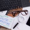 Digital Marketing On Notepad And Various Business Papers On Brown Background. - Auster Inteligência Contábil