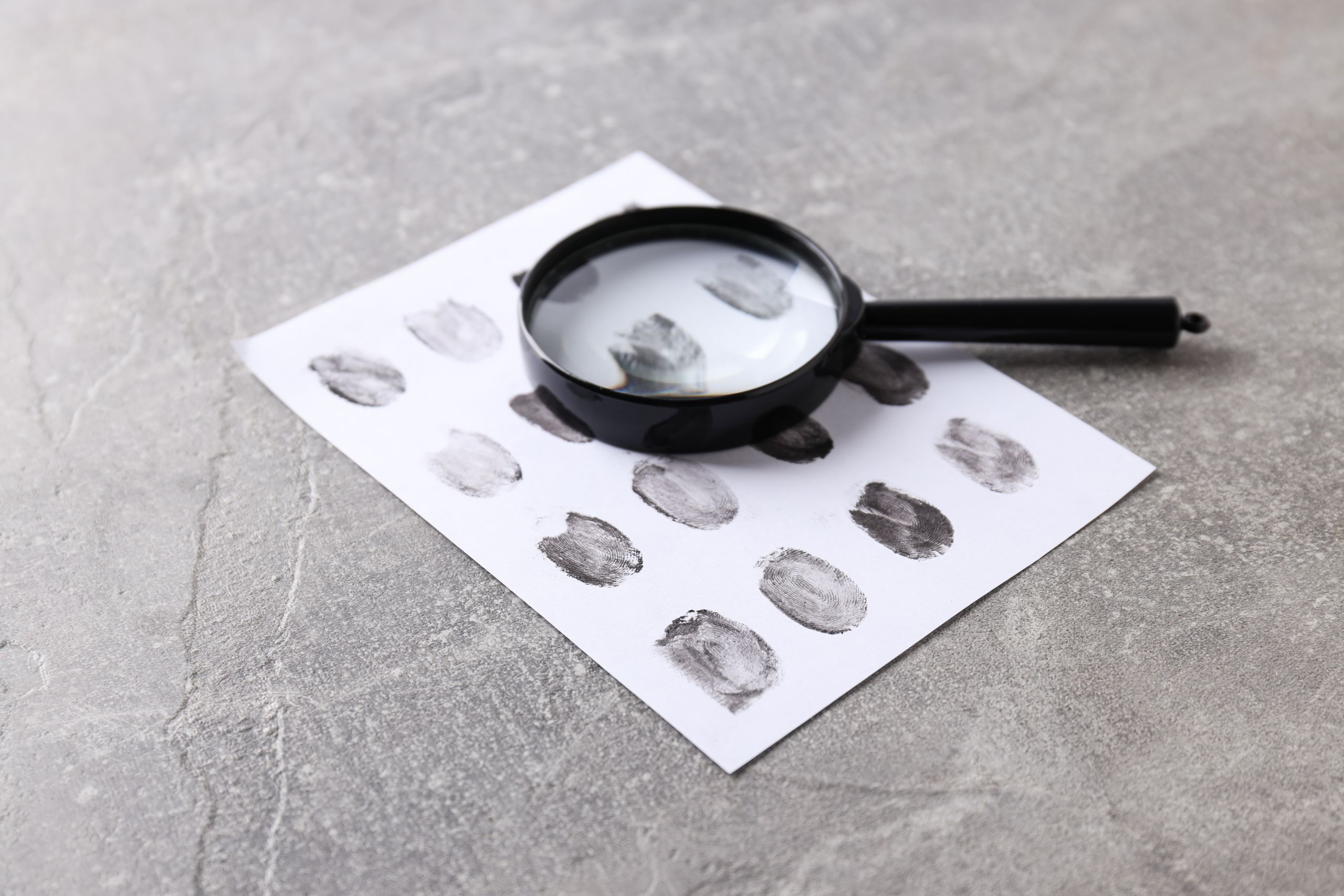 Magnifying Glass With Fingerprints On A Light Background - Auster Inteligência Contábil