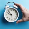 White Vintage Alarm Clock On Empty Blue Color Background - Auster Inteligência Contábil